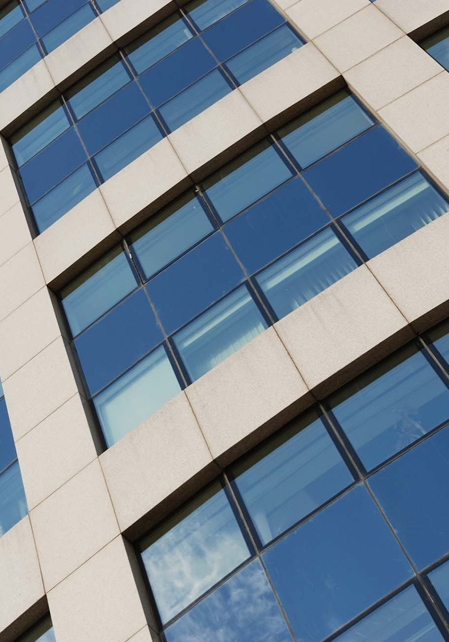 Windows of a shiny skyscraper reflecting clouds
