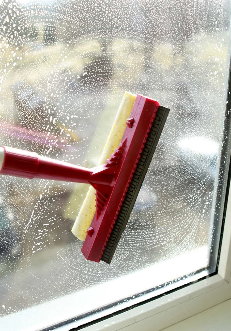Cleaning windows with a squeegee.